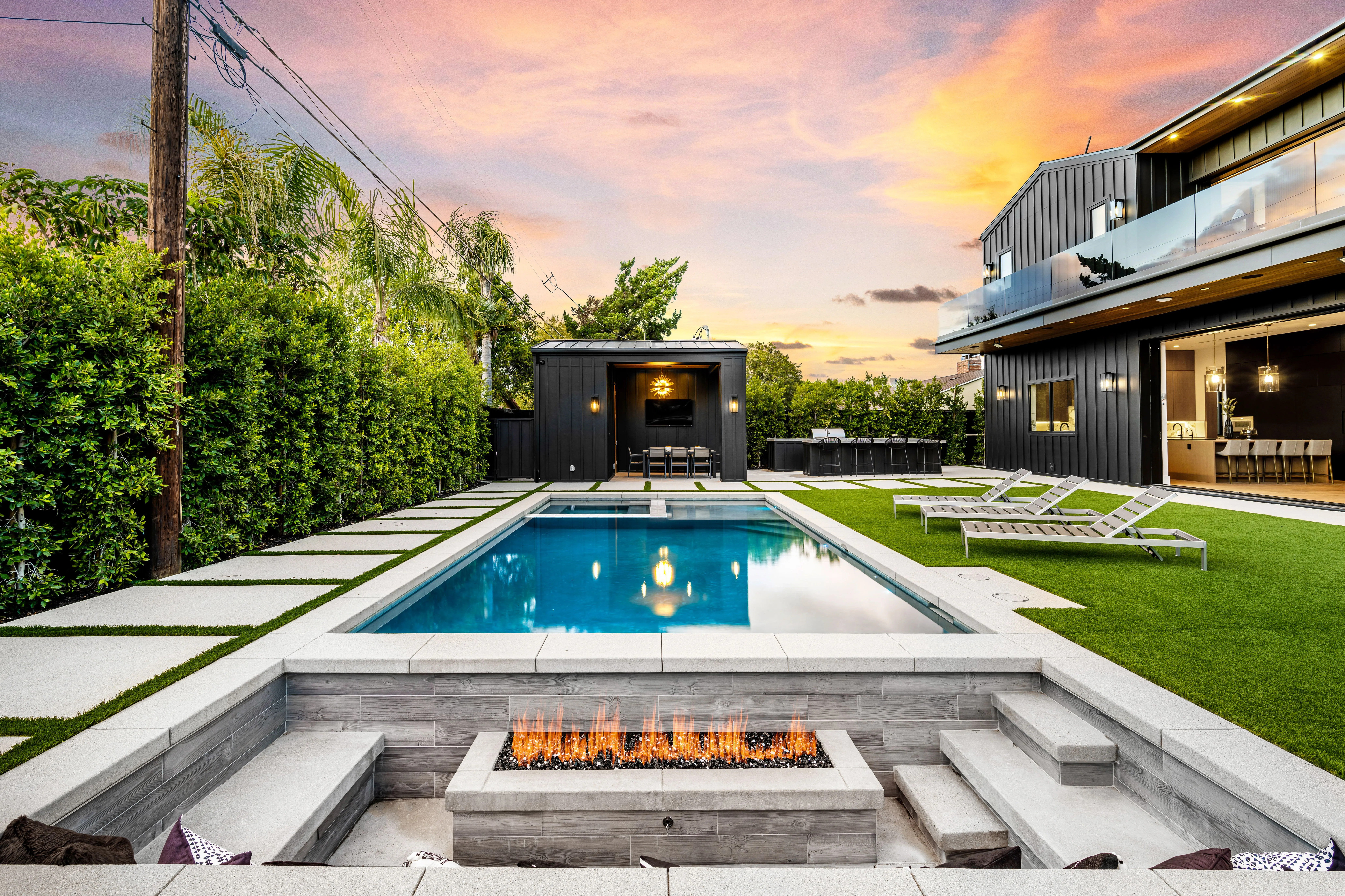 Backyard pool with fire pit at sunset